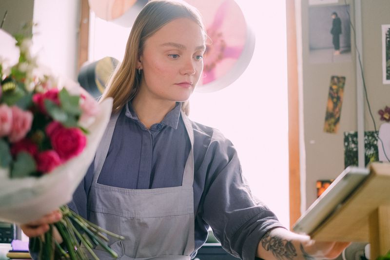 Atelier floral Interflora — artisan fleuriste composant un bouquet